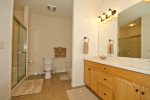 Private large master bathroom with dual sinks, glass encased shower, lower level